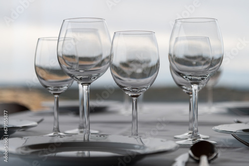Vista de un restaurante con una mesa preparada con mantel, platos, cubiertos y copas de vino.