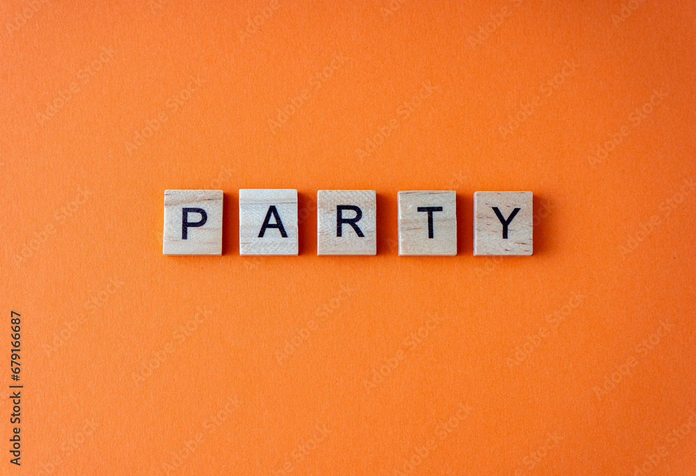 Party word. The phrase is laid out in wooden letters top view. Orange flat lay background Party word. The phrase is laid out in wooden letters top view. Orange flat lay background
