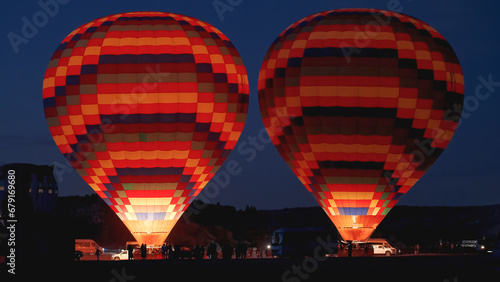 Two multicolored balloons glow from the fire inside, ready to ascend at dawn.