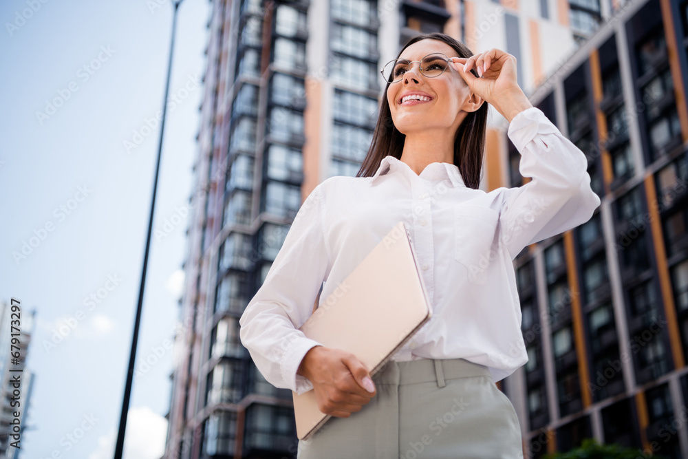 Fototapeta premium Photo of cheerful adorable business lady entrepreneur walking megapolis looking modern town summer morning outside