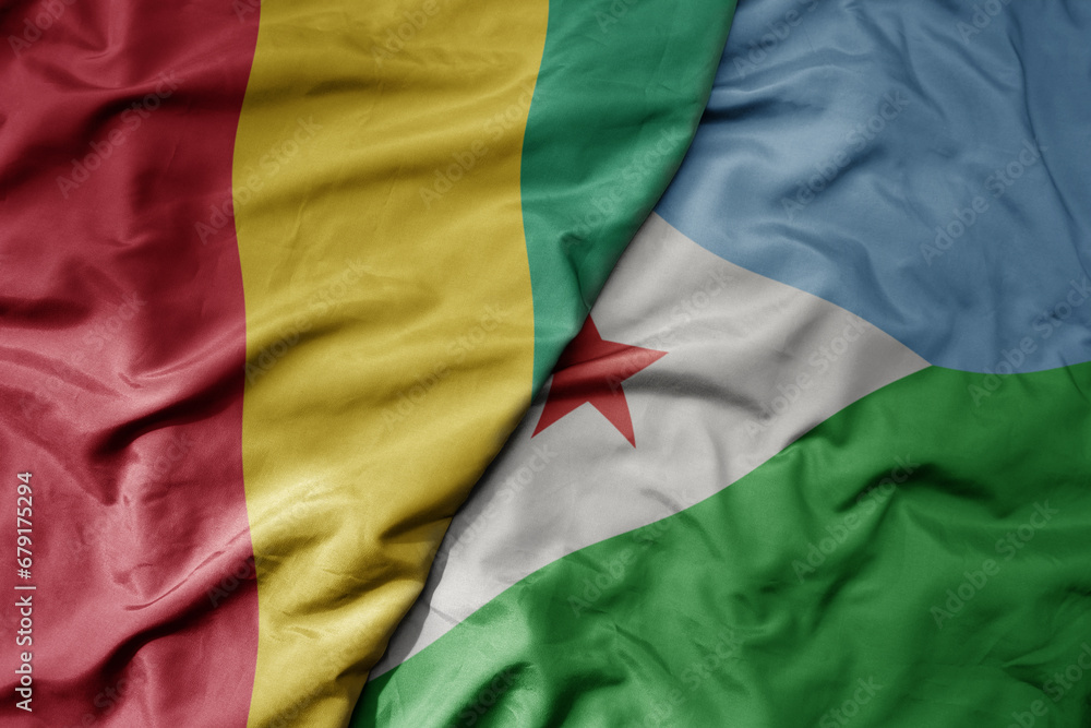 big waving national colorful flag of guinea and national flag of djibouti .