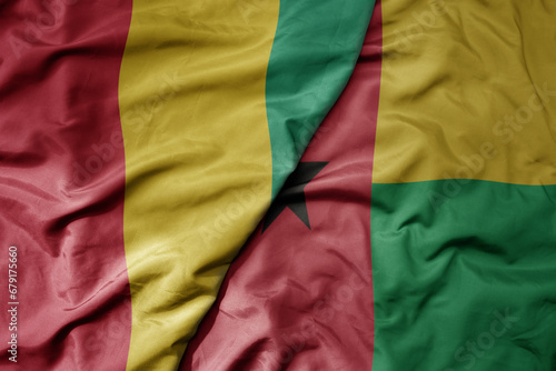 big waving national colorful flag of guinea and national flag of guinea bissau .