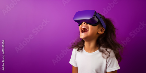 Young girl getting experience using VR headset glasses isolated on a blue background with copy space © dewaai