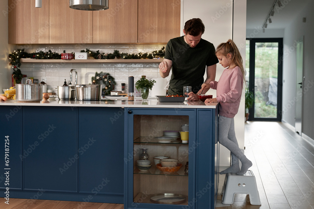 Caucasian daughter and father preparing food before Christmas Caucasian daughter and father preparing food before Christmas