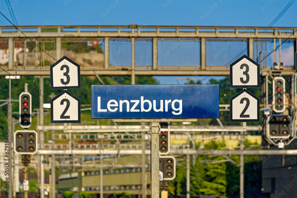 Blue and white sign at railway station at City of Lenzburg on a sunny late spring evening. Photo taken June 11th, 2023, Lenzburg, Switzerland.