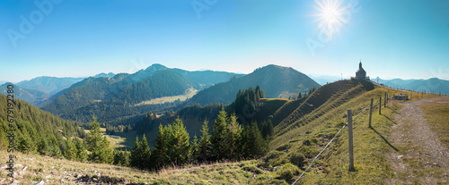 beautiful alpine panorama at Wallberg summit, with view to chapel, bright sun
