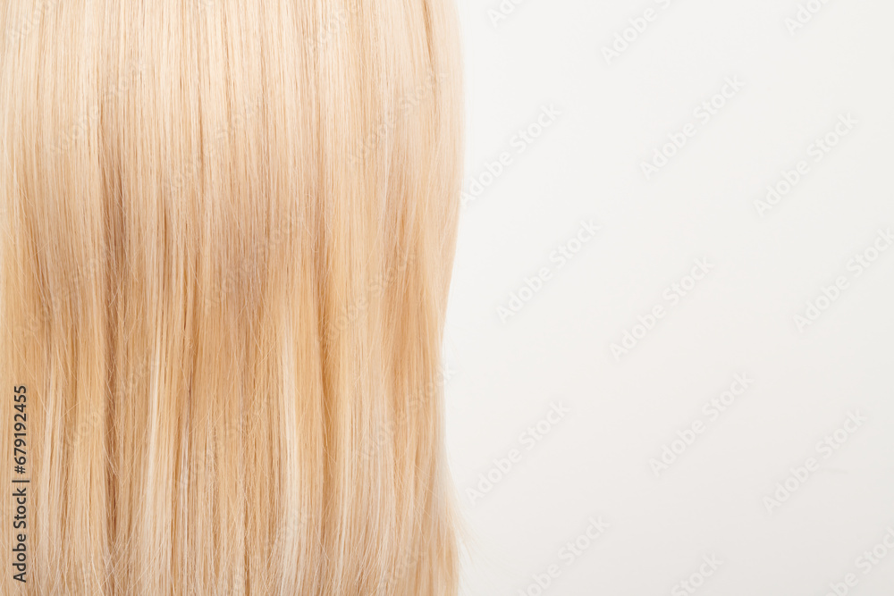 Fototapeta premium Natural looking shiny hair, fair blonde curls isolated on white background with copy space