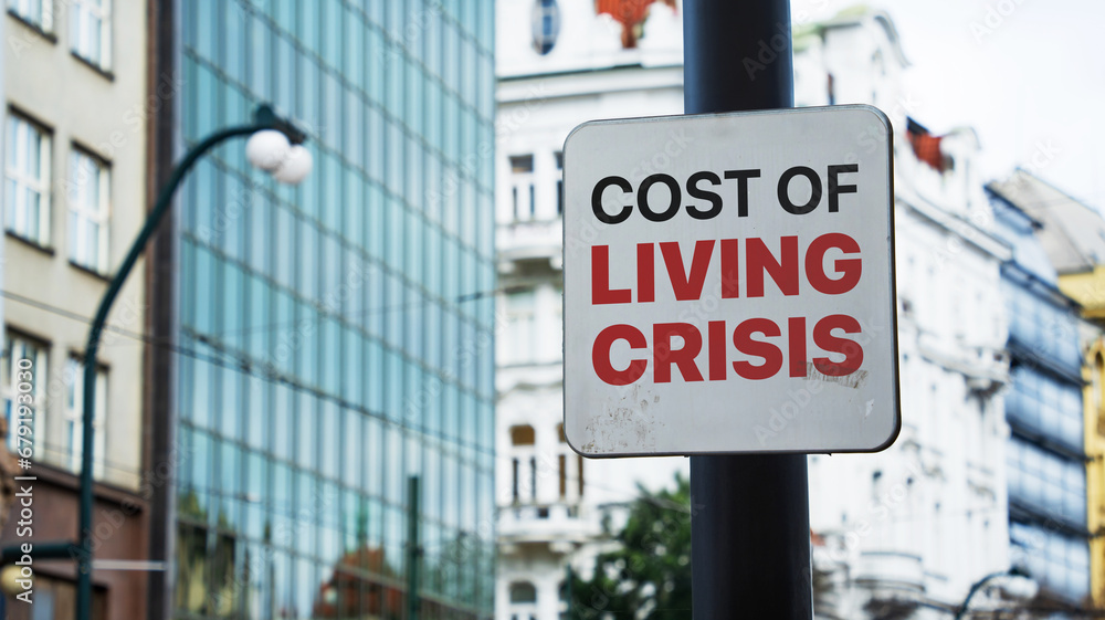 Obraz premium Cost of Living Crisis written on a sign in front of office buildings