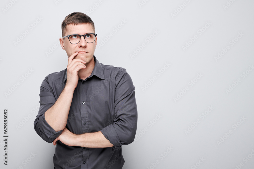Portrait of clever man in shirt touching chin thinks doubts chooses isolated on white studio background with copy space Portrait of clever man in shirt touching chin thinks doubts chooses isolated on white studio background with copy space