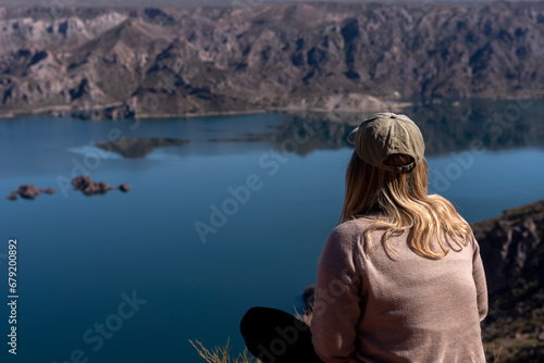 young woman with open arms in a landscape of mountains and free lake on a clear sunny day © Alejandro Piorun