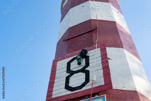 photo of the number 8 on a white wooden shield, red and white pillar, abstraction