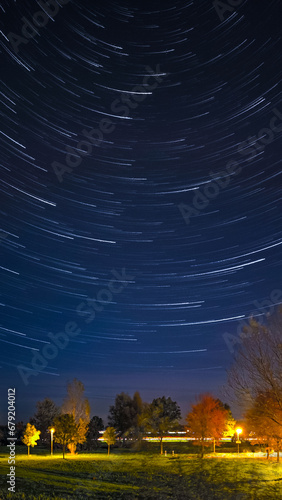 Night image with startrails and autumnal foliage on trees