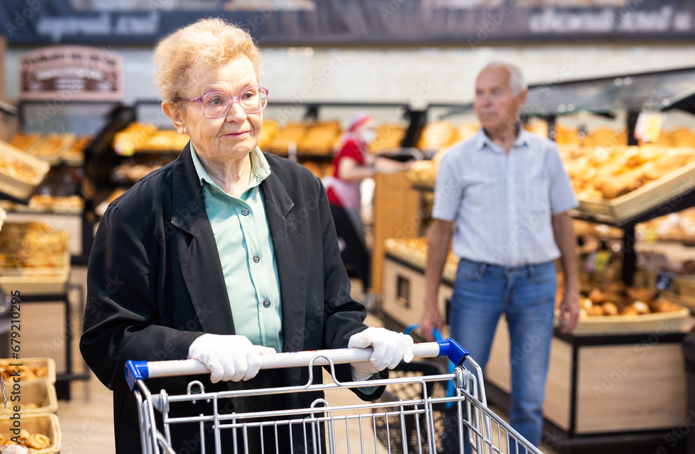Elderly woman with glasses is shopping