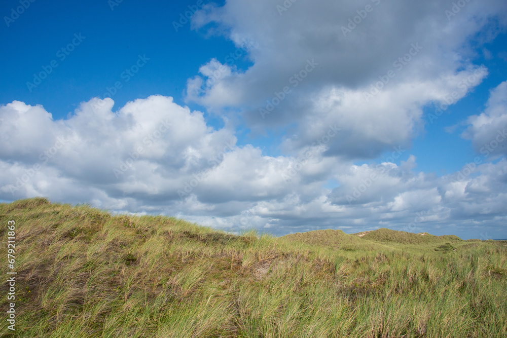 wunderbar ruhige Landschaft mit sanften Dünen, dichtem Strandhafer und weichen Wattewolken