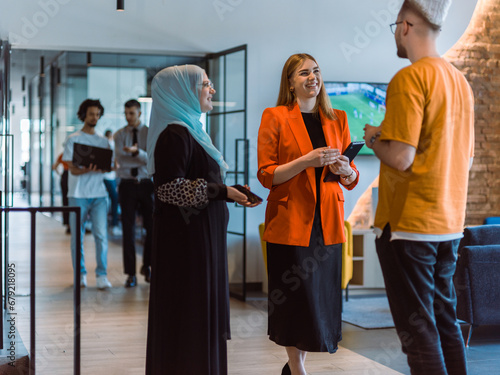Fotografie A group of young business colleagues, including a woman in a hijab, stands unite