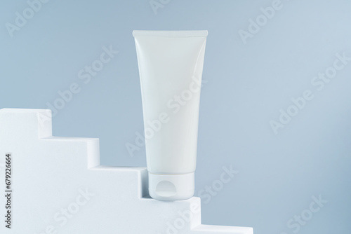 Mockup template of white tube cream or serum on white stairs podium hero view
