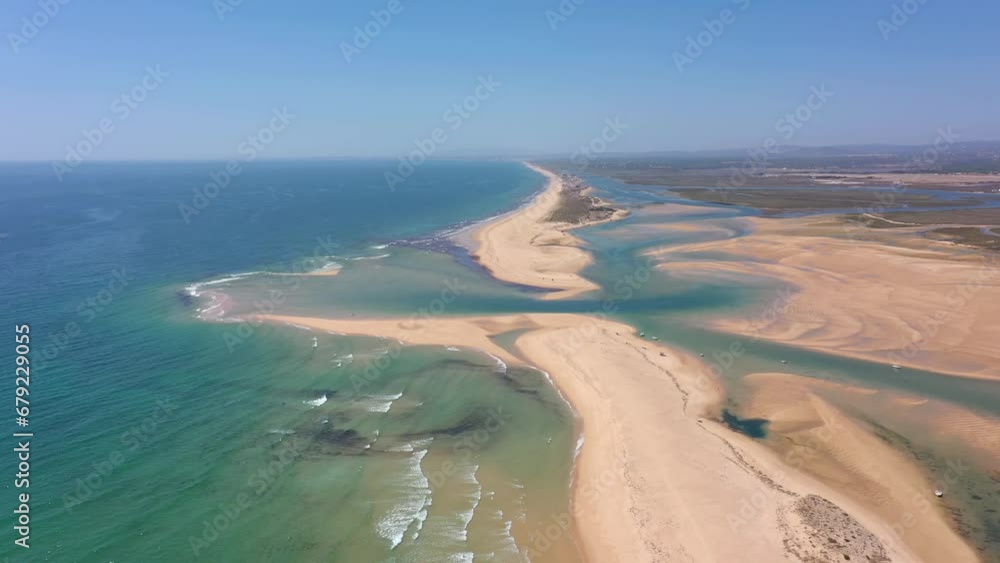 Aerial video filming by drone of the marine reserve Ria Formosa Faro Portugal Algarve. Praia de Barrinha. Flight over the coastal spit between the park and the ocean with a view of the canal. Aerial video filming by drone of the marine reserve Ria Formosa Faro Portugal Algarve. Praia de Barrinha. Flight over the coastal spit between the park and the ocean with a view of the canal.