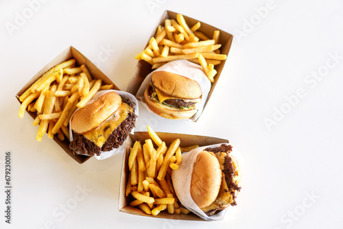Burgers with fries lie on the table in delivery boxes