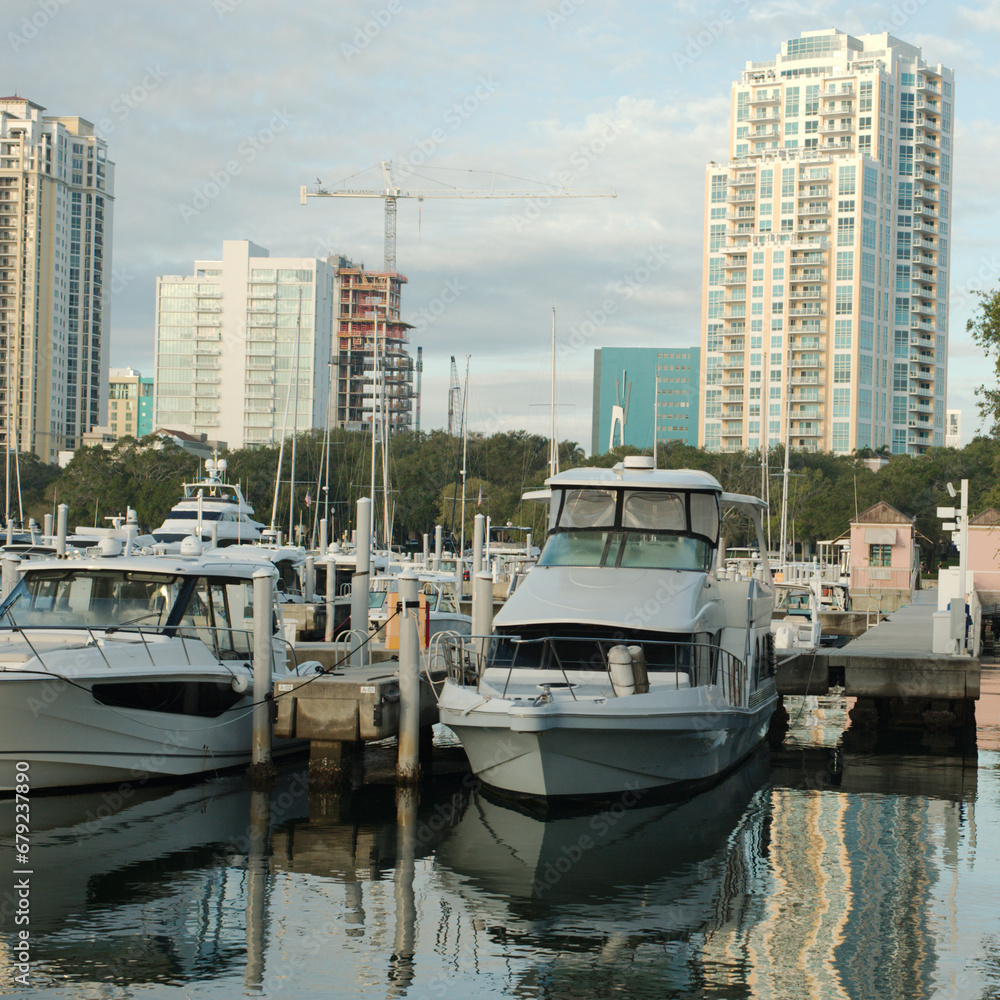 Cityscape of water with tall buildings on a sunny day with boats in the foreground. With a blue sky on a sunny day at the Vinoy  Basin waterfront in St. Petersburg, Florida.
