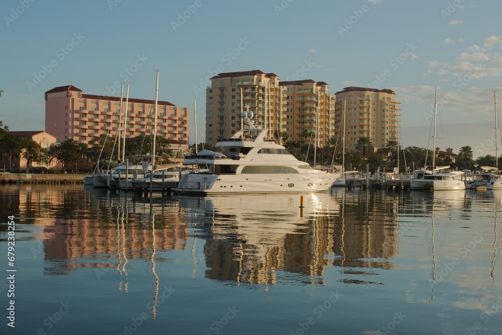 Cityscape of water with tall buildings with reflections on a sunny day with boats in the foreground. With a blue sky on a sunny day at the Vinoy Basin waterfront in St. Petersburg, Florida.