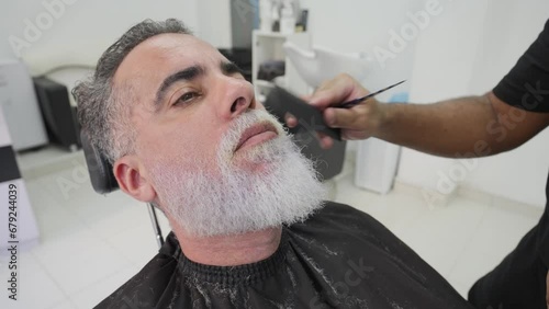 Close-up of handsome man getting his beard combed and shaped.MOV photo