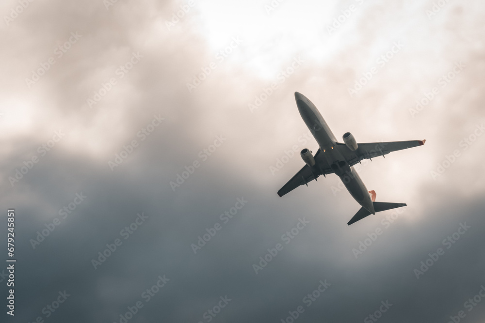 Close-up of a white passenger plane taking off against a gray overcast sky. Travel by air