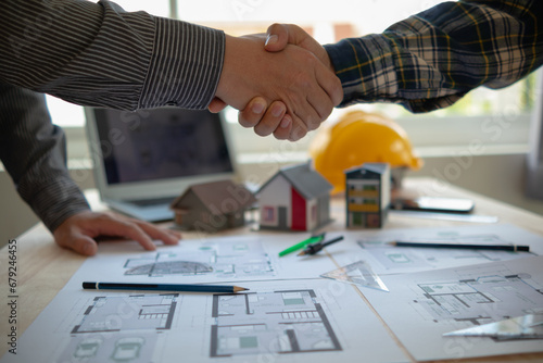 construction engineer joins hands with architect to congratulate housing project that architect team has designed and has been accepted by engineering team. concept of handshake for congratulations