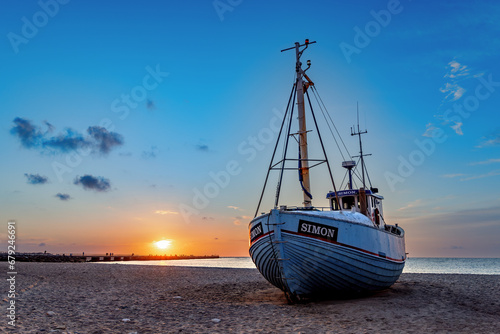 Fotografie, Obraz Fishing boats on the beach at sunset in Vorupor, Denmark.