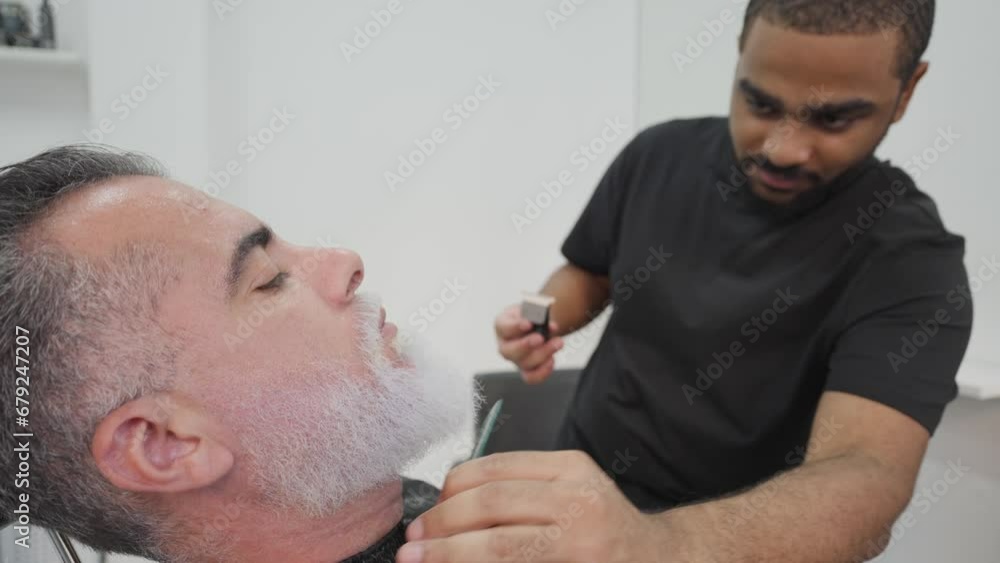 Afro-Latino barber shaping client's dyed beard in hairdressing salon.MOV Afro-Latino barber shaping client's dyed beard in hairdressing salon.MOV