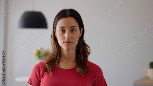 Close up one woman face looking at camera indoors. Confident serious. 

