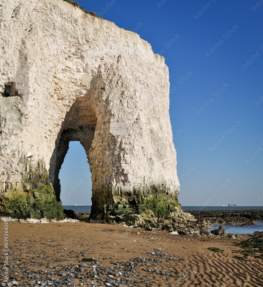 Sandy beach with a majestic cliff against the backdrop of a blue sky. Kingsgate Bay, Kent, England