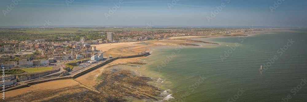 Aerial view of the cityscape and sandy beach surrounded by greenish waters. Margate, Kent, England