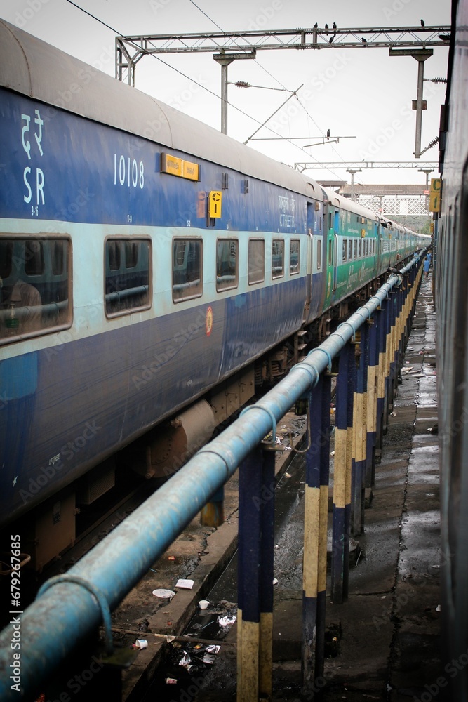 Obraz premium the passenger train is on the tracks at the station platform