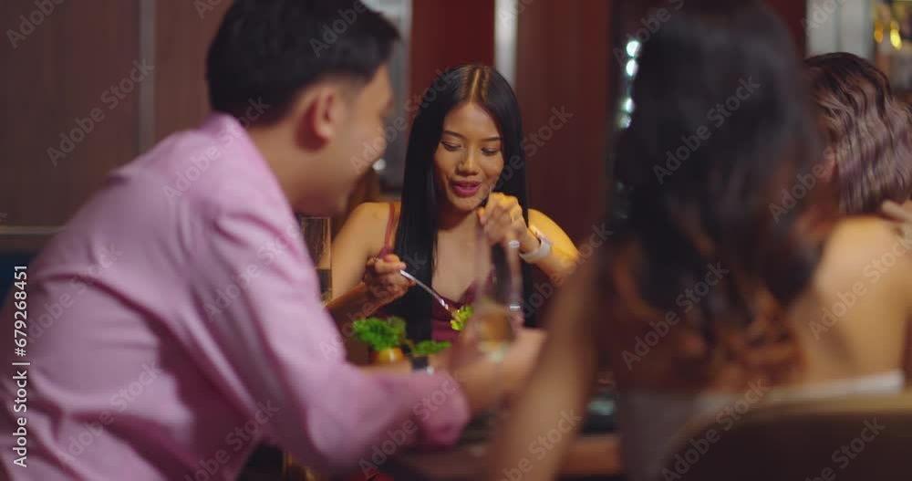 Beautiful Asian woman is Relishing a Delightful Dinner with Friends at a Bar, Immersed in the Joy of a Vibrant Night Party. They Enjoying with Night Party Together. Party and Celebration Concept. Beautiful Asian woman is Relishing a Delightful Dinner with Friends at a Bar, Immersed in the Joy of a Vibrant Night Party. They Enjoying with Night Party Together. Party and Celebration Concept.