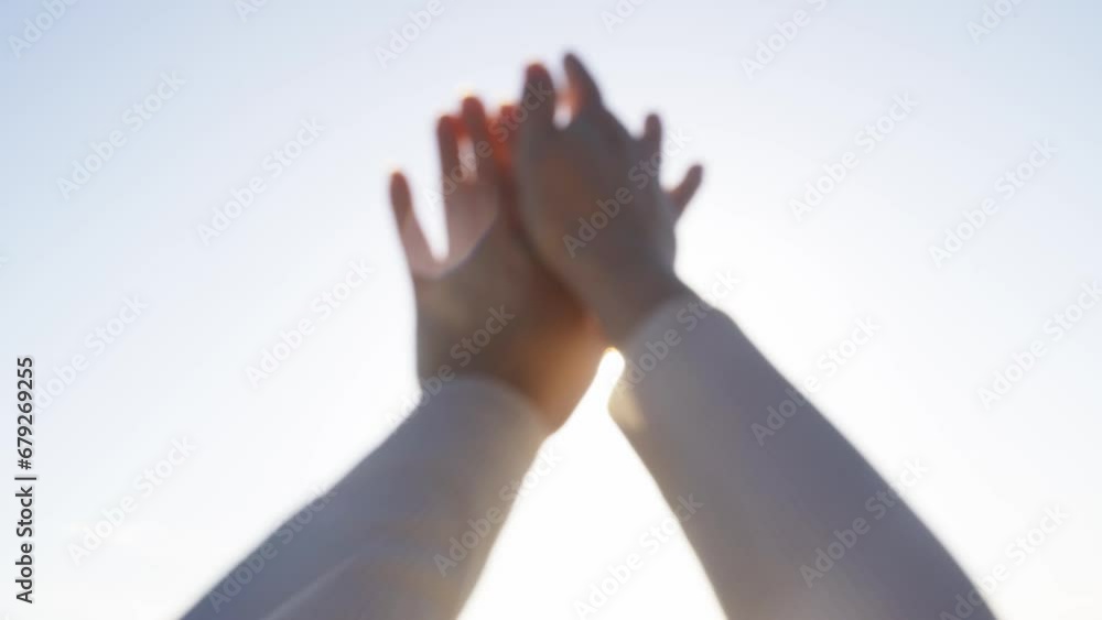 A woman relaxes, plays with the rays of the sun with her hands, covering them. Close-up. Selective sharpening. A woman relaxes, plays with the rays of the sun with her hands, covering them. Close-up. Selective sharpening.