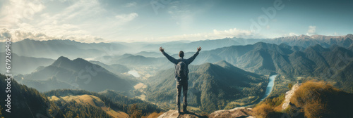 Traveler standing on top of a mountain with hands raised up , mission success and goal achieved, active tourism and mountain travel photo
