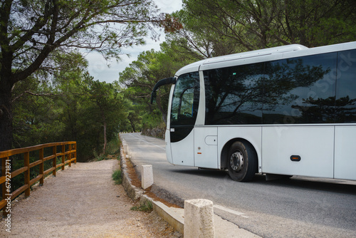 White tourist bus going around tight corner in a mountain