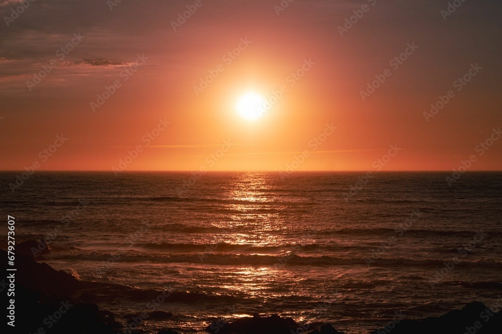 Scenic view of sea waves reflecting a red sunset