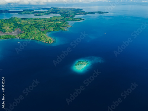 Aerial view with coral reef in ocean and island in tropics. © artifirsov