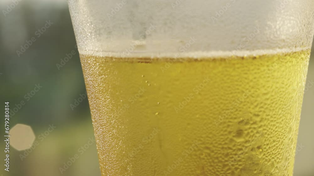 A delicious cold drink with bubbling, rests in a glass, ready to be enjoyed. The amber liquid, with its refreshing foam and the promise of a tasty celebration, glistens in the natural sunlight. A delicious cold drink with bubbling, rests in a glass, ready to be enjoyed. The amber liquid, with its refreshing foam and the promise of a tasty celebration, glistens in the natural sunlight.