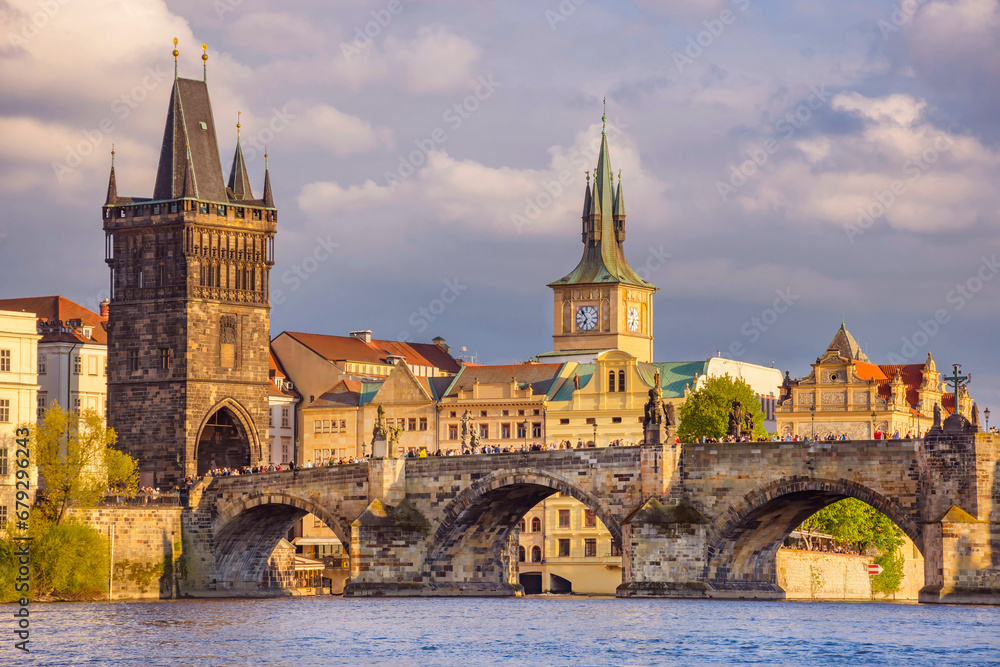 Charles Bridge (Karluv Most) on Vltava river and Old Town Bridge Tower, famous tourist destination in Prague, Czech Republic (Czechia), at sunset