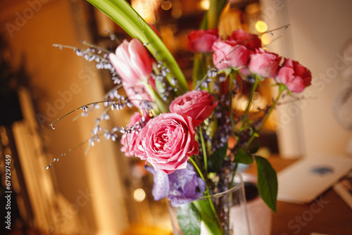 A vaz with flowers on the bar with glasses and wine photo