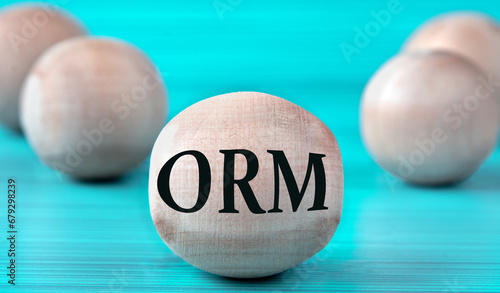 The letters ORM are depicted on a wooden round ball on a blue background photo