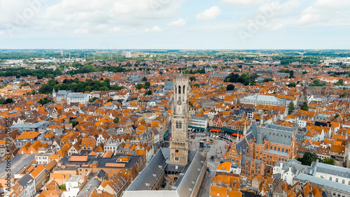 Bruges, Belgium. Belfort - Medieval bell tower and market square. Panorama of the city center from the air. Cloudy weather, summer day, Aerial View