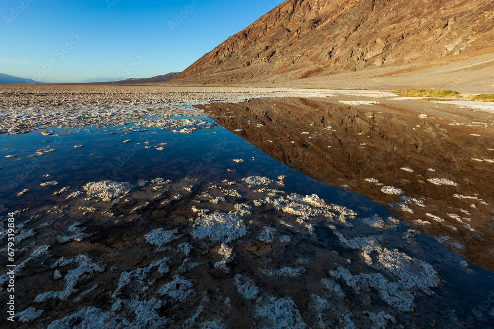 Hypersaline lake, reflection of a mountain in the water, Dry cracked earth in Salt Flats