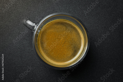 Glass Cup of Espresso coffee. Top view, on a black background, free copy space. Natural coffee.