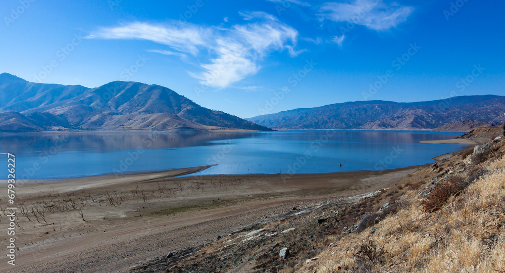 Shallow mountain lake, dry tree trunks at the bottom of a dry lake Shallow mountain lake, dry tree trunks at the bottom of a dry lake