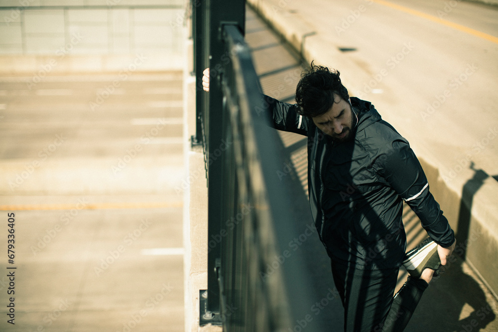 Man Stretching During an Urban Outdoor Workout Man Stretching During an Urban Outdoor Workout
