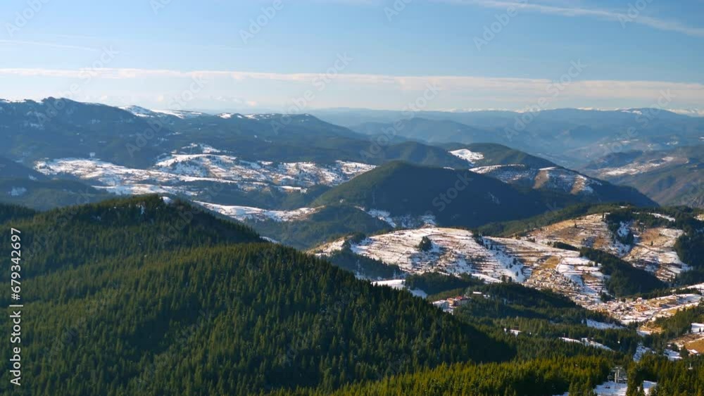 Pamporovo winter resort from the top. Mountain ridges over blue sky with spruce forest in the foreground and layers of hills. Macedonian Pine (Pinus peuce) grow on slopes at Snezhanka peak, Rhodopi mo Pamporovo winter resort from the top. Mountain ridges over blue sky with spruce forest in the foreground and layers of hills. Macedonian Pine (Pinus peuce) grow on slopes at Snezhanka peak, Rhodopi mo