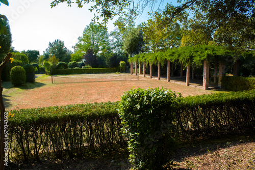 Abandoned and semi-destroyed red clay tennis court. It is located in Villa Marlia located in Capannori, near Lucca in Tuscany, Italy. The playing field is empty and no one can fit there. photo